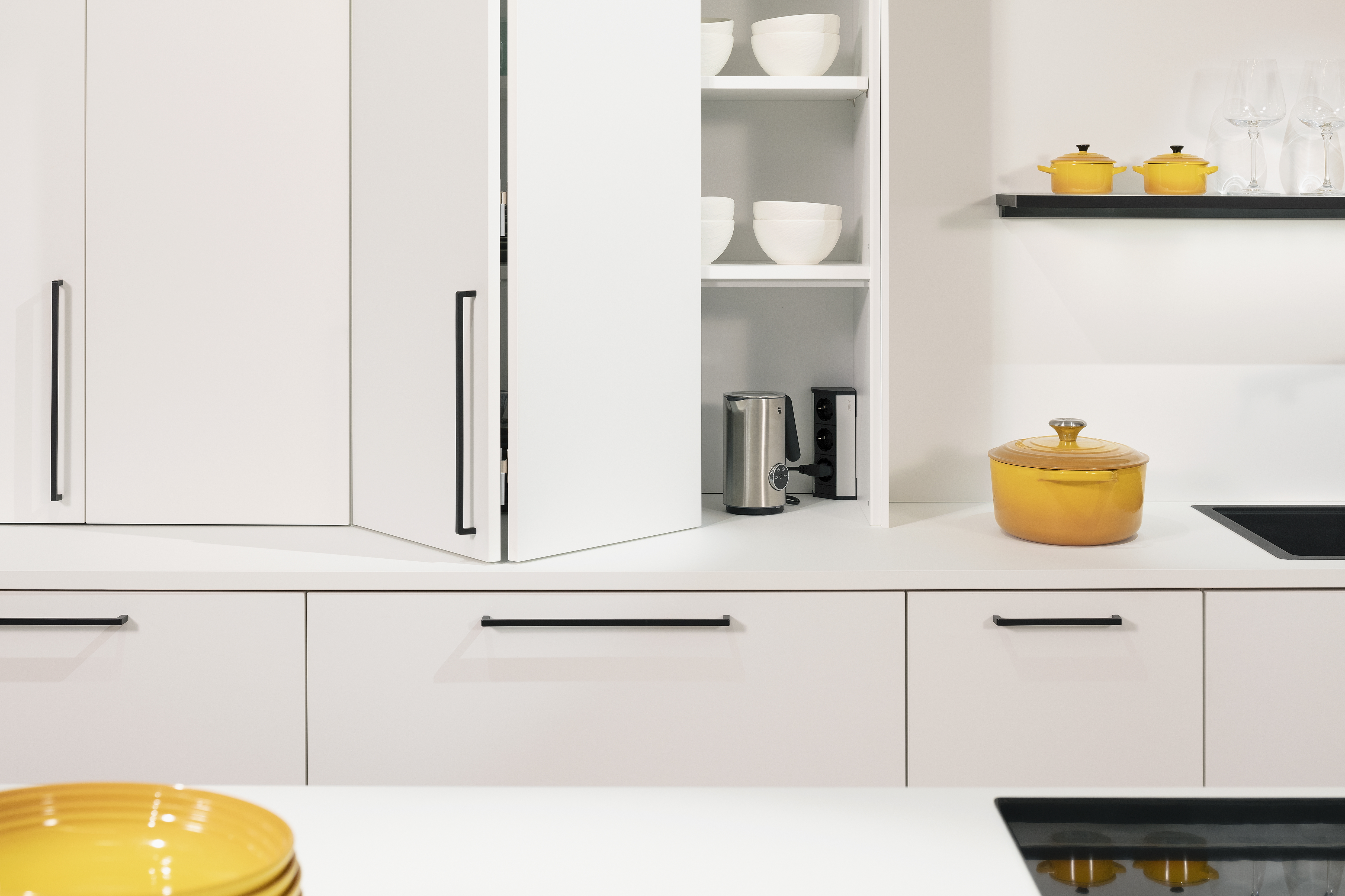 Kristallweiße Küchenzeile von Häcker mit offenem Schrank. 