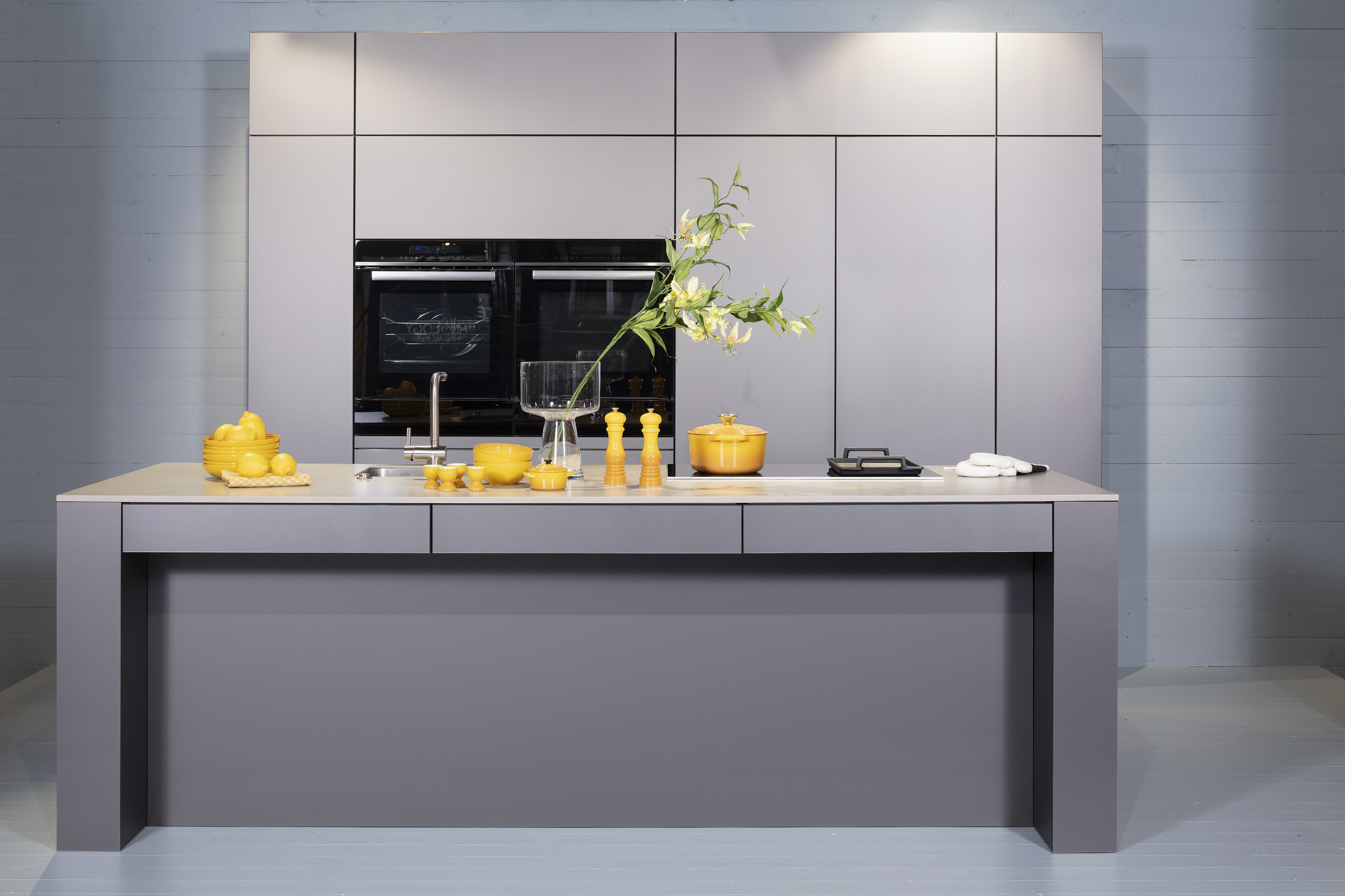 Häcker-Küche in Sandgrau metallic ohne Stühlen als frontaler Vollschuss. 