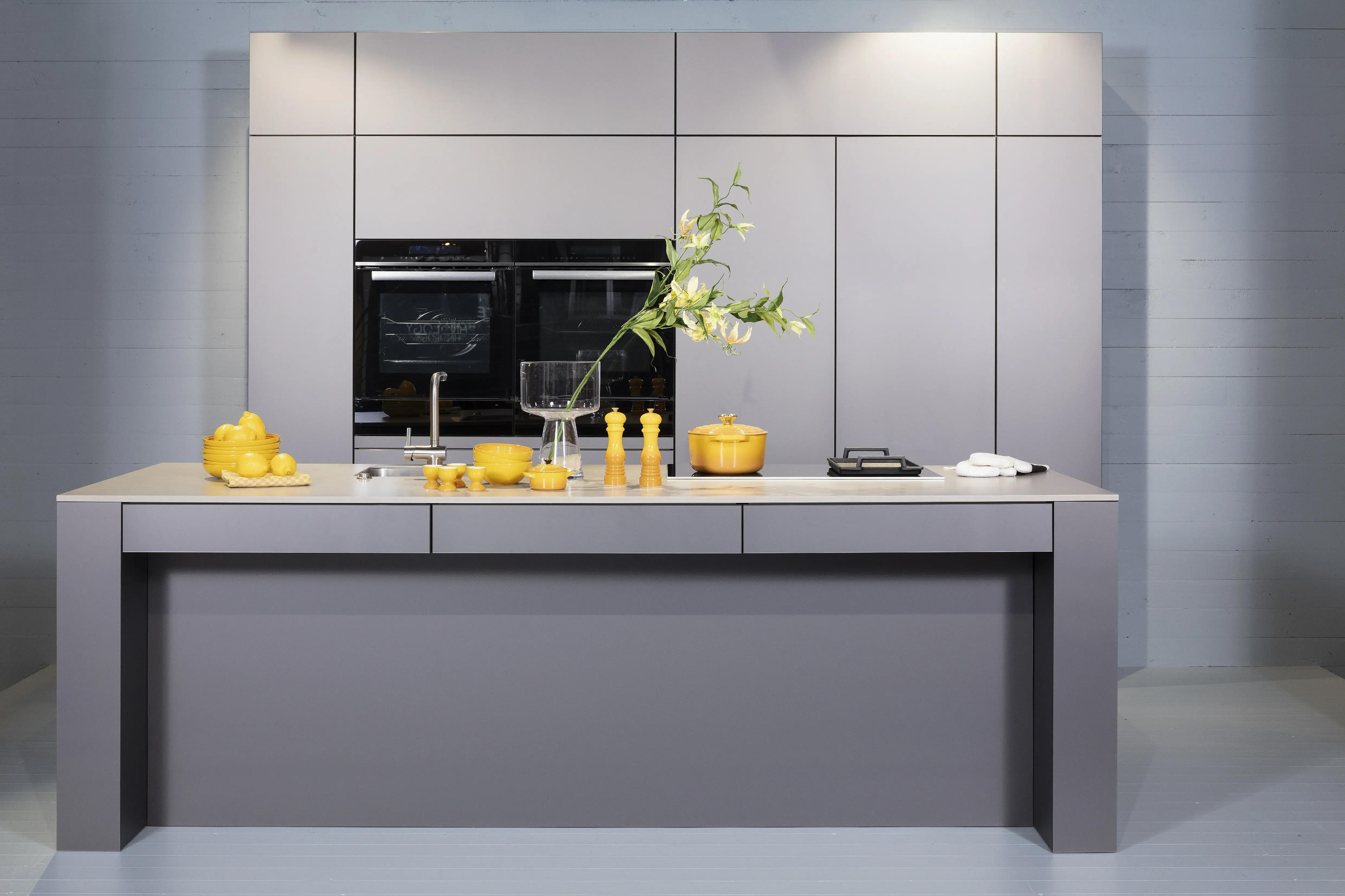 Häcker-Küche in Sandgrau metallic ohne Stühlen als frontaler Vollschuss. 